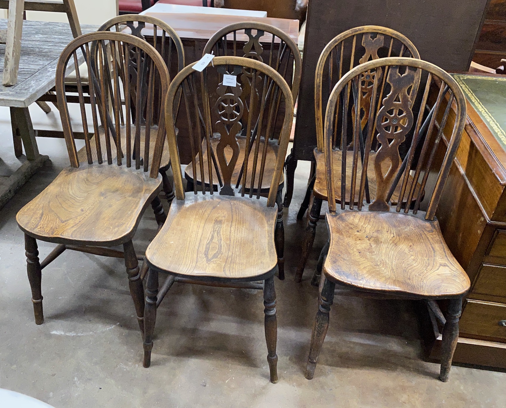 A set of six (5 plus 1) Victorian ash and elm Windsor wheel and comb back dining chairs